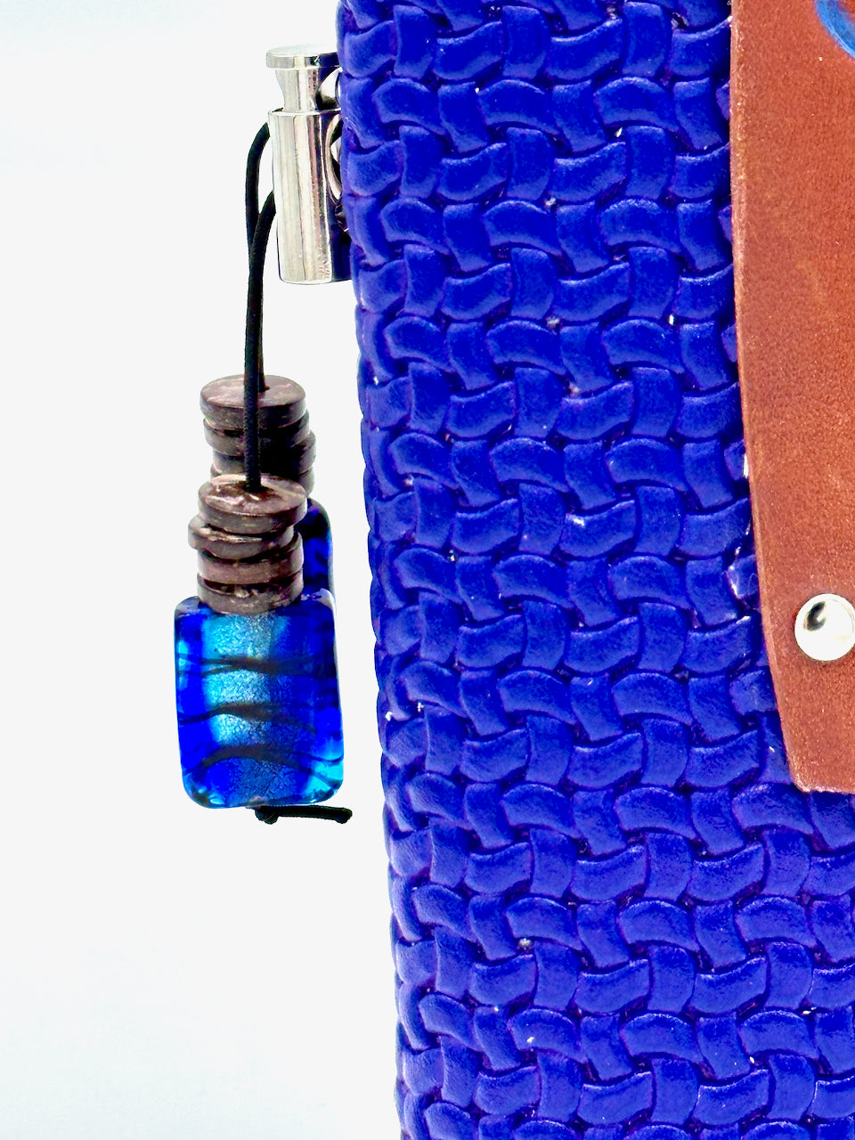 detail of pretty glass bead that hangs on elastic toggle on blue leather journal