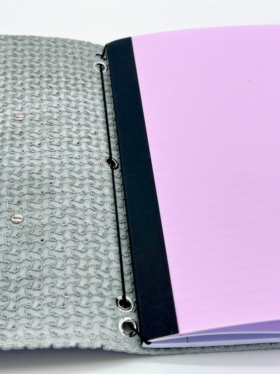 inside front cover shows elastic cord that makes it easy to remove or add additional paper notebook inserts into the leather journal