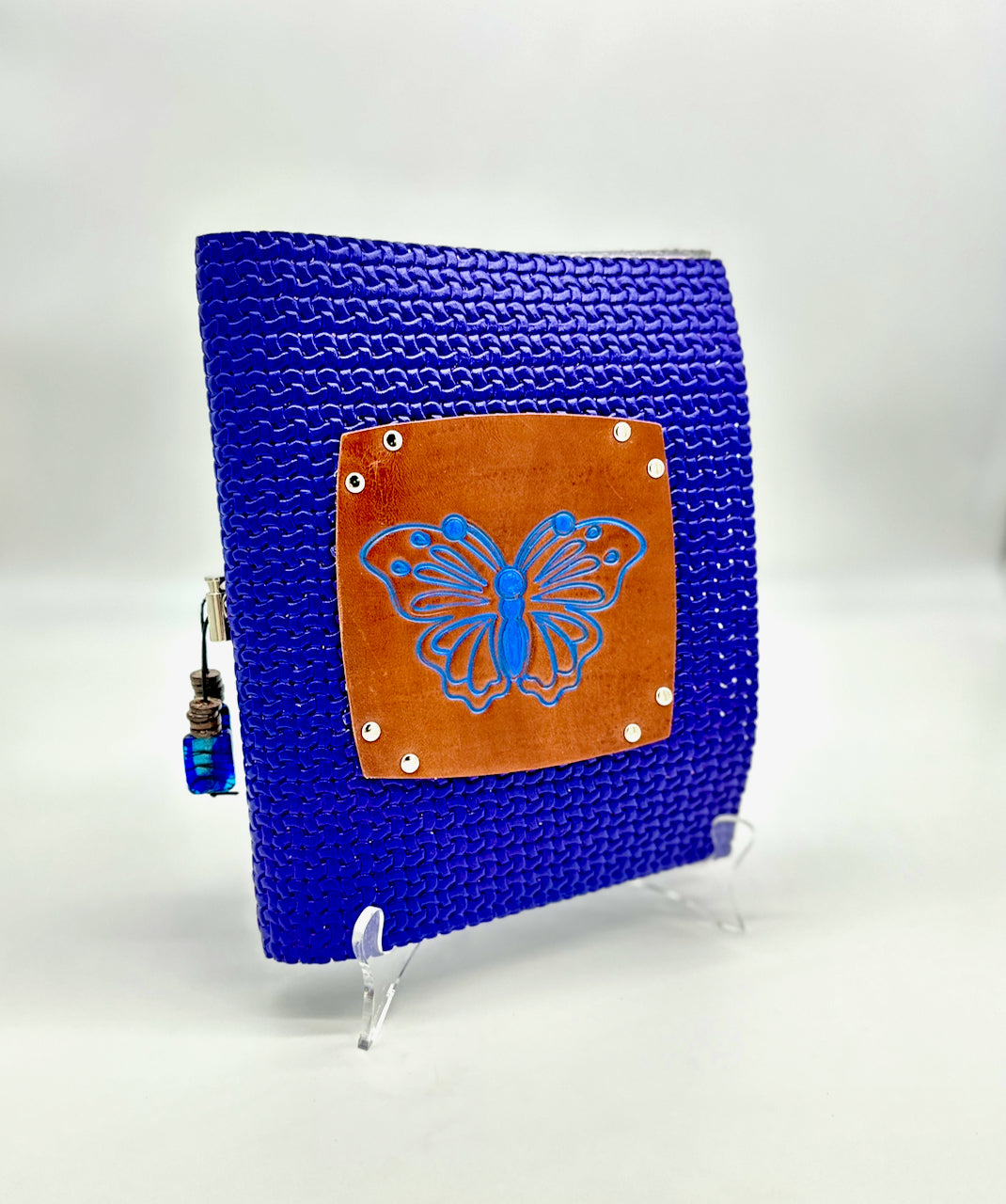 upright blue leather journal with a brown imprinted butterfly that is inked with blue