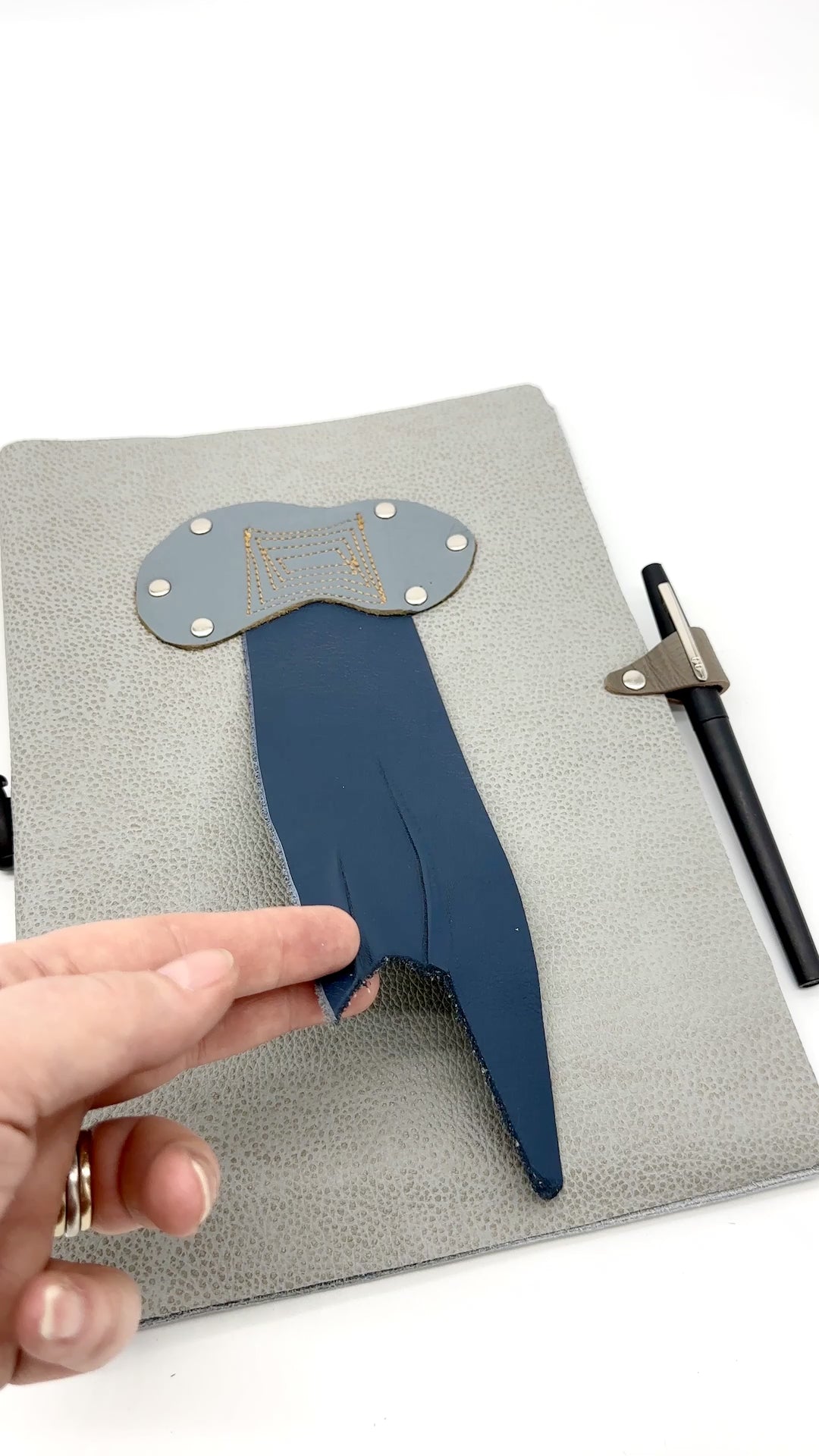 video showing front and back cover of leather journal with rain cloud and thunderbolt
