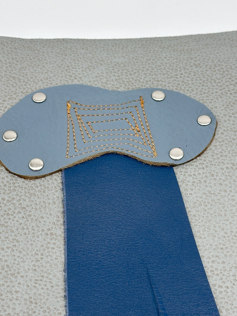 detail of rain cloud with tan stitching on leather journal